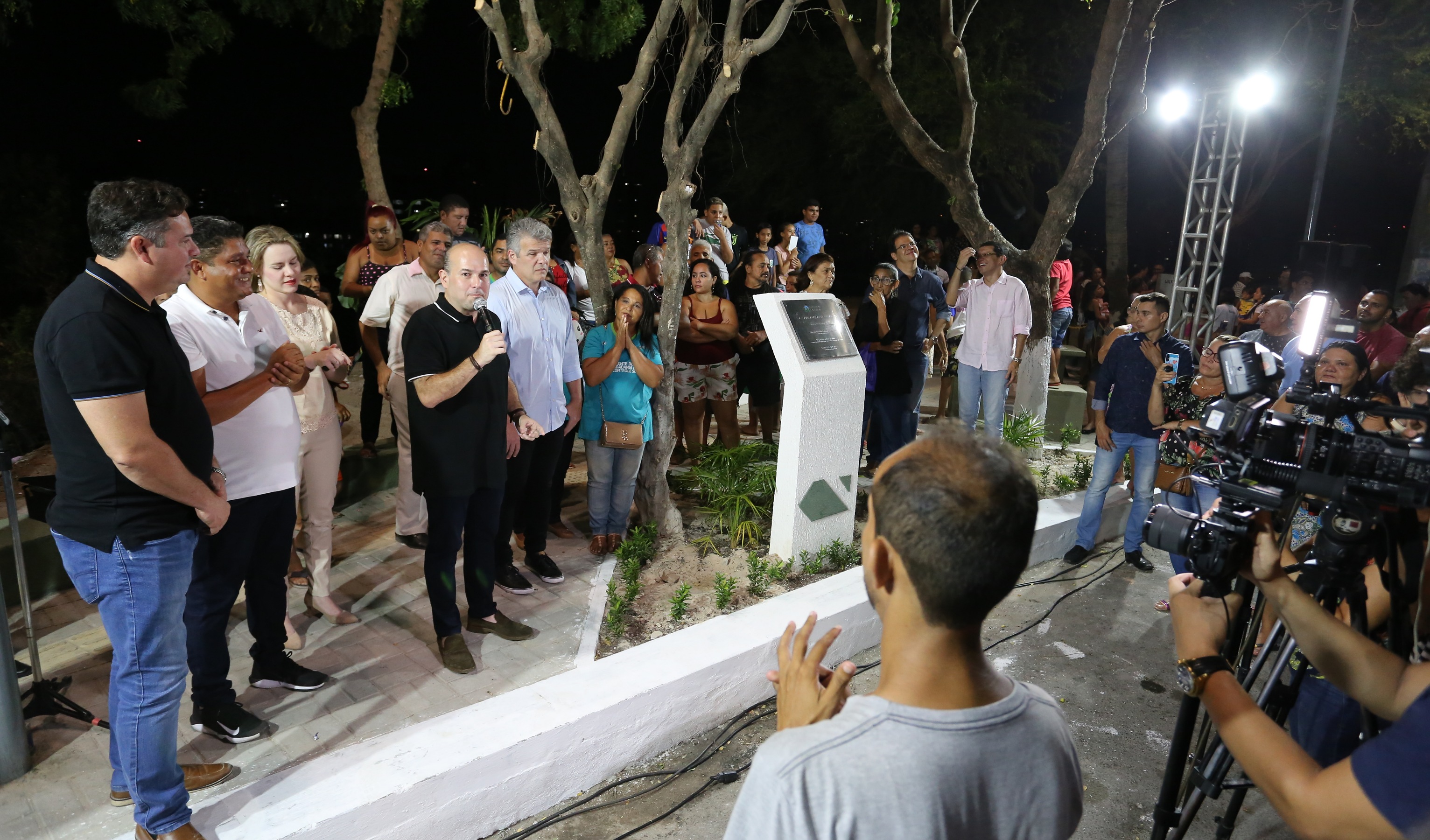 prefeito fala ao microfone em um palco montado na praça